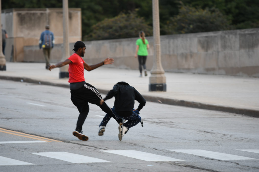 Hispanic man being kicked from behind.